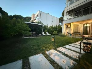 a yard with a building and a table and chairs at Garden View Apartment in Rrushkull