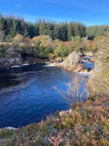a river with a group of boats in the water at Sputieburn Bothy in Brora +12 photos