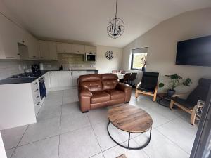 a kitchen and a living room with a couch and a table at Sputieburn Bothy in Brora