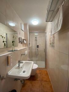a white bathroom with a shower and a sink at Altstadthotel Marktheidenfeld in Marktheidenfeld +30 photos