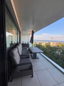 a balcony with a couch and a table on a building at VOGH Olimp Premium Sea View Escape in Olimp