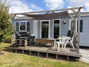 a house with a wooden deck with chairs and a table at Chalet Conference in Hengstdijk