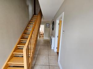 a hallway with wooden stairs in a house at Letterkenny View in Letterkenny +1 photo
