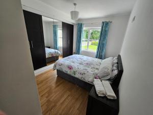a small bedroom with a bed and a mirror at Letterkenny View in Letterkenny