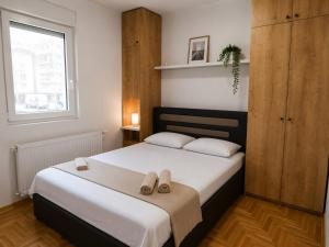 a bedroom with a bed with two slippers on it at Lux apartman Ub II in Ub