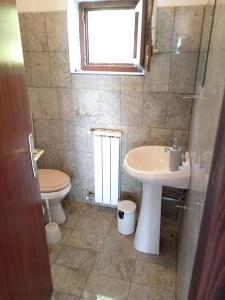 a bathroom with a sink and a toilet and a window at Kuća u zelenilu in Poljane