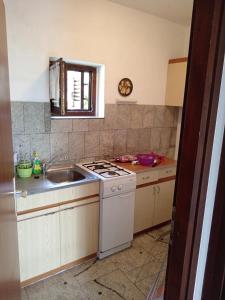 a kitchen with a sink and a stove at Kuća u zelenilu in Poljane