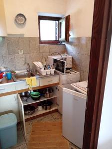 a small kitchen with a sink and a stove at Kuća u zelenilu in Poljane +5 photos