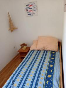 a bedroom with a bed with a blue comforter at Kuća u zelenilu in Poljane