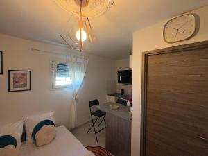 a bedroom with a clock on the wall and a table at Prince in Perrigny-lès-Dijon