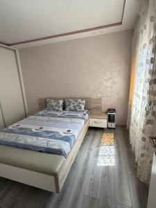 a bedroom with a bed and a wooden floor at appart plage in M'diq
