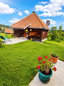 a house with two pots of flowers in a yard at Brvnara Zlatni mir in Vodice
