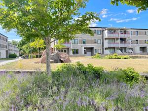 an apartment building with a tree and a field of flowers at 4 person holiday home in VISBY in Visby