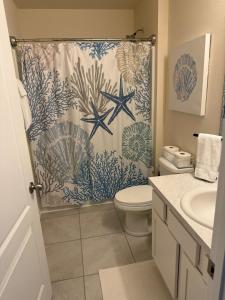 a bathroom with a shower curtain and a toilet at Rybark Manor in Palm Coast +23 photos
