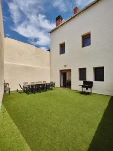 a building with tables and benches in a yard at Villa Rural in Cabezuela