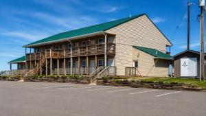 a large white building with a green roof at Tumbleweed Inn & Suites in Alexander