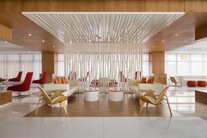 a lobby with chairs and tables and a dining room at Novotel Jeddah Tahlia in Jeddah