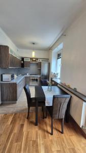a kitchen with a table and chairs in a room at Kościuszki Centrum Apartment in Łódź +2 photos