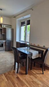 a kitchen with a table and chairs in a room at Kościuszki Centrum Apartment in Łódź