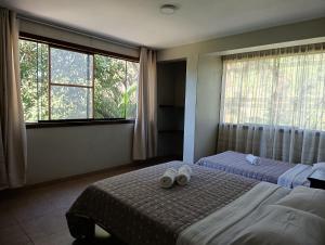 a bedroom with two beds with white shoes on them at Montañita Lodge in La Merced +16 photos