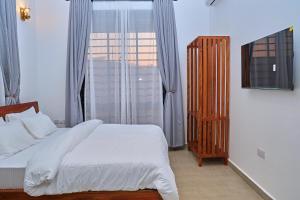 a bedroom with a bed and a large window at Villa Maisha in Arusha +47 photos