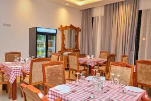 a restaurant with tables and chairs and a mirror at Villa Maisha in Arusha