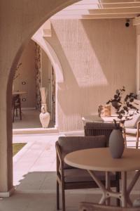 a room with an archway and tables and chairs at Lentischi Hotel - Adults Only in Villasimius