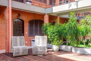 two chairs sitting on a deck in front of a building at Elite Hotel in Florianópolis +54 photos