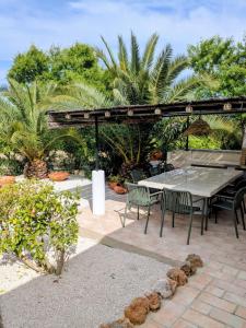 a patio with a table and chairs under a pergola at Quinta Do Priorado in Moncarapacho