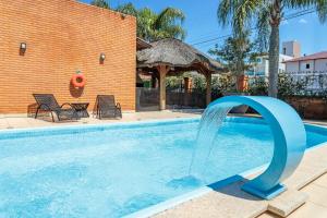 a pool with a water fountain in a yard at Elite Hotel in Florianópolis