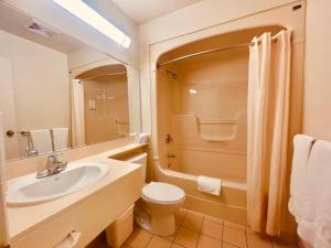 a bathroom with a sink and a toilet and a shower at Econo Lodge Airport Quebec in Quebec City +25 photos