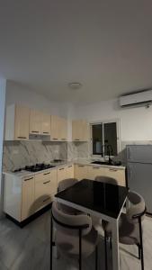 a kitchen with white cabinets and a black table and chairs at Casa Mo in Akouda