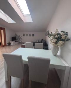 a dining room table with chairs and a vase with flowers at Apartmán Nádvorie in Levoča