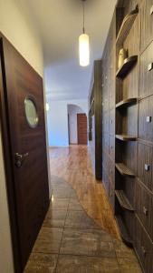 a hallway with wooden walls and a door with shelves at Kościuszki Centrum Apartment in Łódź
