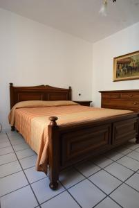 1 dormitorio con cama de madera y colcha de color naranja en Lungomare, en Marciana Marina