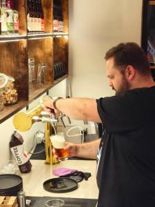 a man is holding a glass of beer at Camp & Hostel Maltakva in Poti