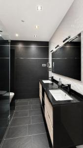 a black bathroom with a sink and a mirror at ELAN LEVEL Parla in Parla