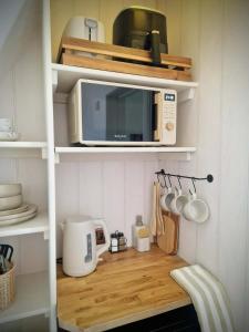 a kitchen with a microwave and a wooden counter top at Stone Cottage Relax & Unwind, Cosy Cinema Retreat in Laurencekirk