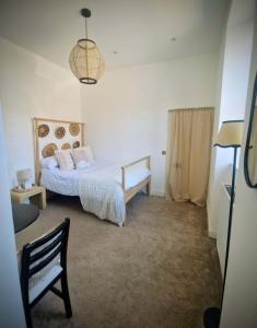 a bedroom with a bed and a chair in it at Stone Cottage Relax & Unwind, Cosy Cinema Retreat in Laurencekirk