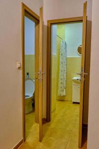 an open door to a bathroom with a toilet and a sink at Villa Axa in Vrbov