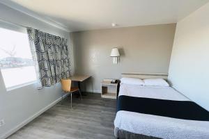 a room with two beds and a desk and a window at Motel 6-Holbrook, AZ in Holbrook +17 photos