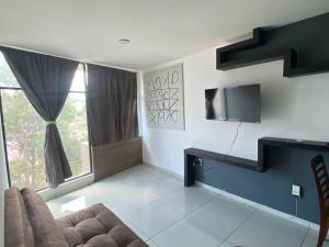 a living room with a couch and a tv at Hermoso Departamento Ejecutivo 2 in Guadalupe