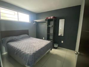 a small bedroom with a bed and a mirror at Hermoso Departamento Ejecutivo 2 in Guadalupe