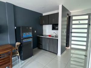 a kitchen with a black refrigerator and a table at Hermoso Departamento Ejecutivo 2 in Guadalupe