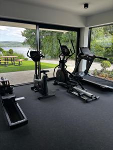 a gym with three exercise bikes and a large window at Przystań NADOLE- APARTAMENT in Nadole