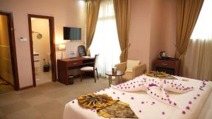 a hotel room with two beds and a desk at Amdina Hotel in Mekʼelē