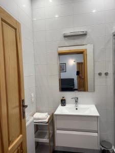 a white bathroom with a sink and a mirror at Willa Pod Platanem in Bytów