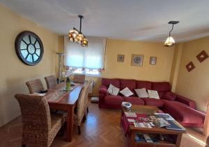 a living room with a red couch and a table at Oasis Segovia in San Cristóbal de Segovia