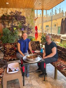 a man and a woman sitting at a table with a cake at Eman house in Wadi Musa