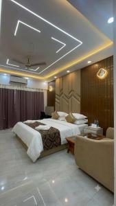 a hotel room with a large bed and a couch at V studio in Ghaziabad